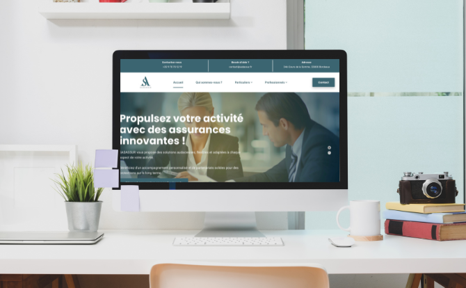 Un écran dordinateur affiche un site Web en français sur des services dassurance innovants. Le bureau est équipé de notes autocollantes, dune plante en pot, de livres, dun appareil photo et dun carnet de notes. Larrière-plan comprend une fenêtre avec des stores.